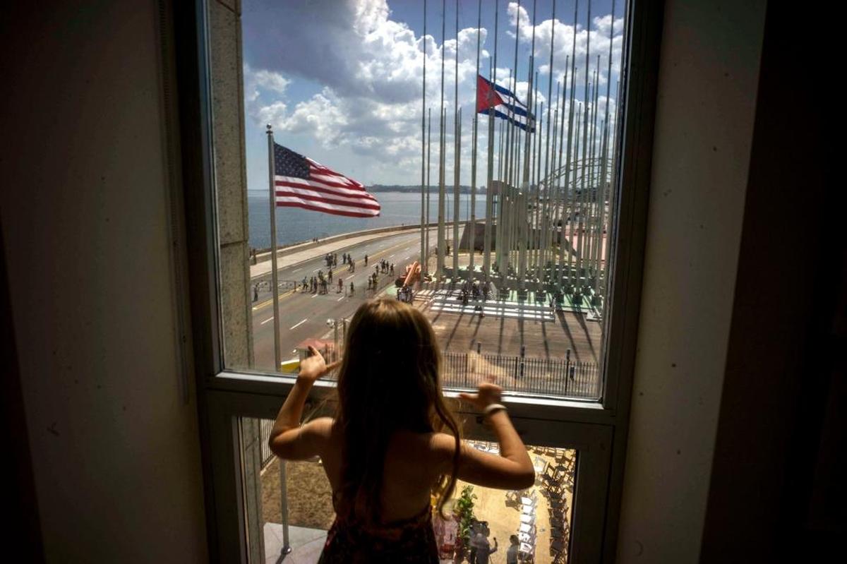 A child looks out a window from inside the newly opened U.S. Embassy during a flag-raising ceremony on Aug. 14, 2015. Although cooperation and meetings of topics of mutual interest continue between the U.S. and Cuba, the relationship has gone cold since President Donald Trump took office.