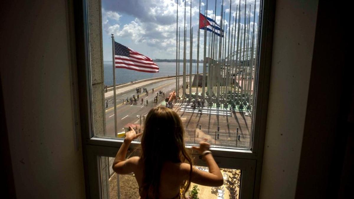 A child looks out a window from inside the newly opened U.S. Embassy during a flag-raising ceremony on Aug. 14, 2015. Although cooperation and meetings of topics of mutual interest continue between the U.S. and Cuba, the relationship has gone cold since President Donald Trump took office.