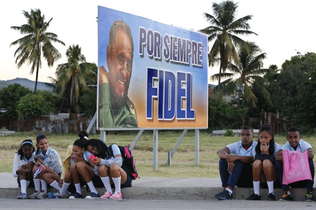Children wait for the arrival of the caravan carrying the ashes of Fidel Castro on the road to Cemeterio Santa Ifigenia in Santiago de Cuba on Sunday, Dec. 4, 2016.