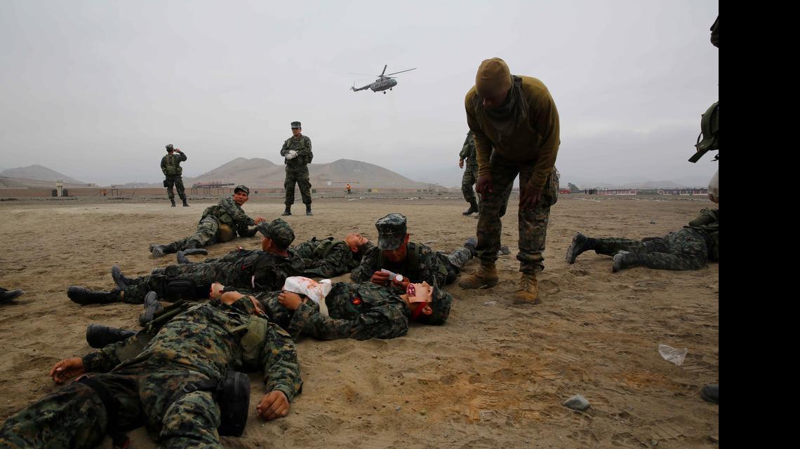 
Petty Officer 2nd Class Brad Olton, right, a Navy hospital corpsman with Special Purpose Marine Air Ground Task Force South, and a native of Kingston, Jamaica, provides a stressful environment by yelling at Peruvian Marines for the final exercise of a Combat Lifesaver course during a theater security cooperation bi-lateral exchange at Peruvian Marine Corps Base Ancon, Peru, Sept. 2, 2014. The exrcise covered medical treatment, improvised explosive device detection, mixed martial arts and combat marksmanship to confront what was described as “transnational security challenges through integrated and coordinated approaches.” 
