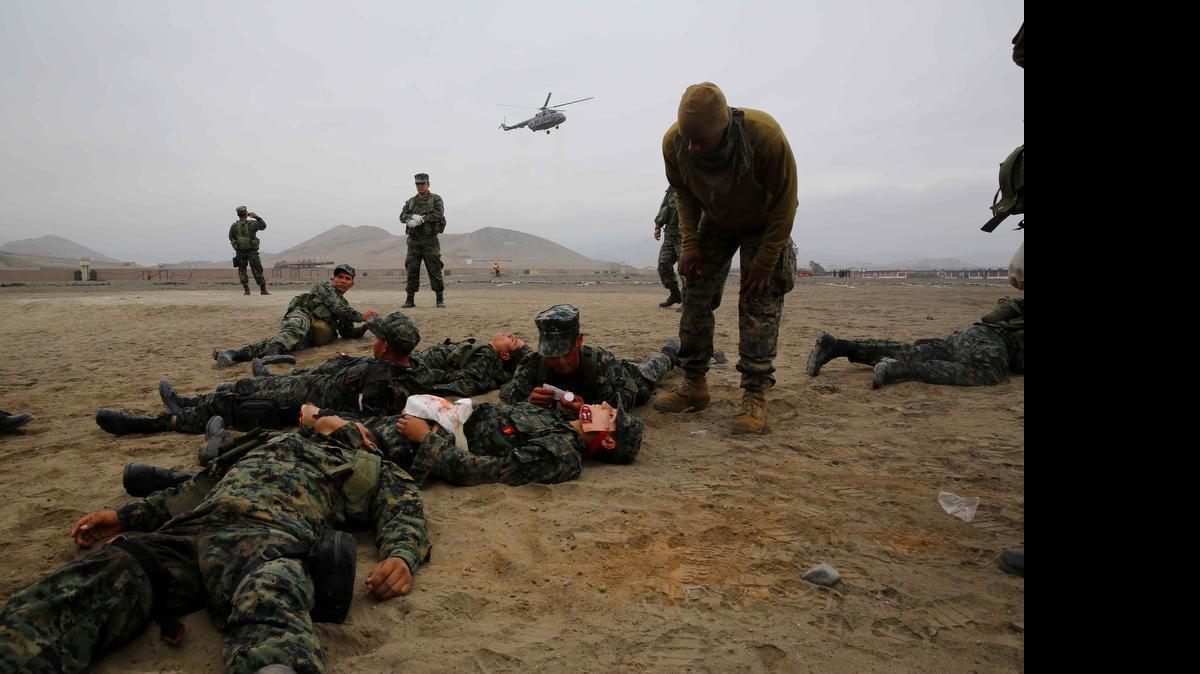 
Petty Officer 2nd Class Brad Olton, right, a Navy hospital corpsman with Special Purpose Marine Air Ground Task Force South, and a native of Kingston, Jamaica, provides a stressful environment by yelling at Peruvian Marines for the final exercise of a Combat Lifesaver course during a theater security cooperation bi-lateral exchange at Peruvian Marine Corps Base Ancon, Peru, Sept. 2, 2014. The exrcise covered medical treatment, improvised explosive device detection, mixed martial arts and combat marksmanship to confront what was described as “transnational security challenges through integrated and coordinated approaches.” 
