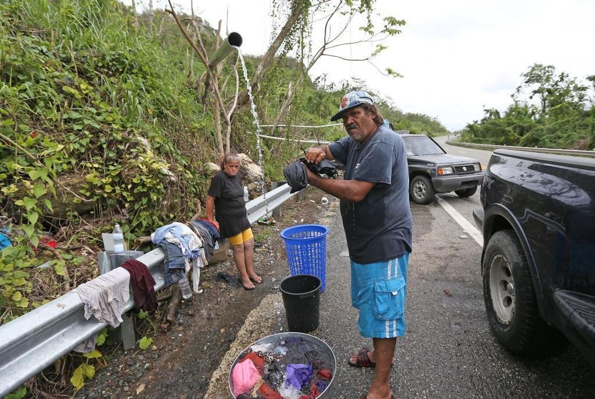 Utuado resident Wilfredo Cosme de Jesus and his wife Maria Rodriguez Rivera wash their clothes on the side of the highway in Utuado. Cosme de Jesus said he got leptospirosis, a bacterial disease spread through contaminated water, a few weeks after Hurricane Maria.