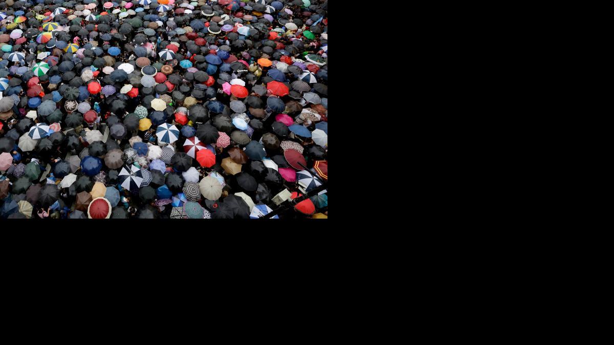 
People holding umbrellas gather in Plaza de Mayo to demand answers from the government in the mysterious death of prosecutor Alberto Nisman one month ago in Buenos Aires, Argentina, Wednesday, Feb. 18, 2015. Nisman was found dead of a gunshot wound Jan. 18, hours before he was to detail to Congress his explosive accusations that President Cristina Fernandez and top administration officials orchestrated a secret deal with Iran to shield officials allegedly responsible for the 1994 bombing of a Jewish community center in Buenos Aires. 
