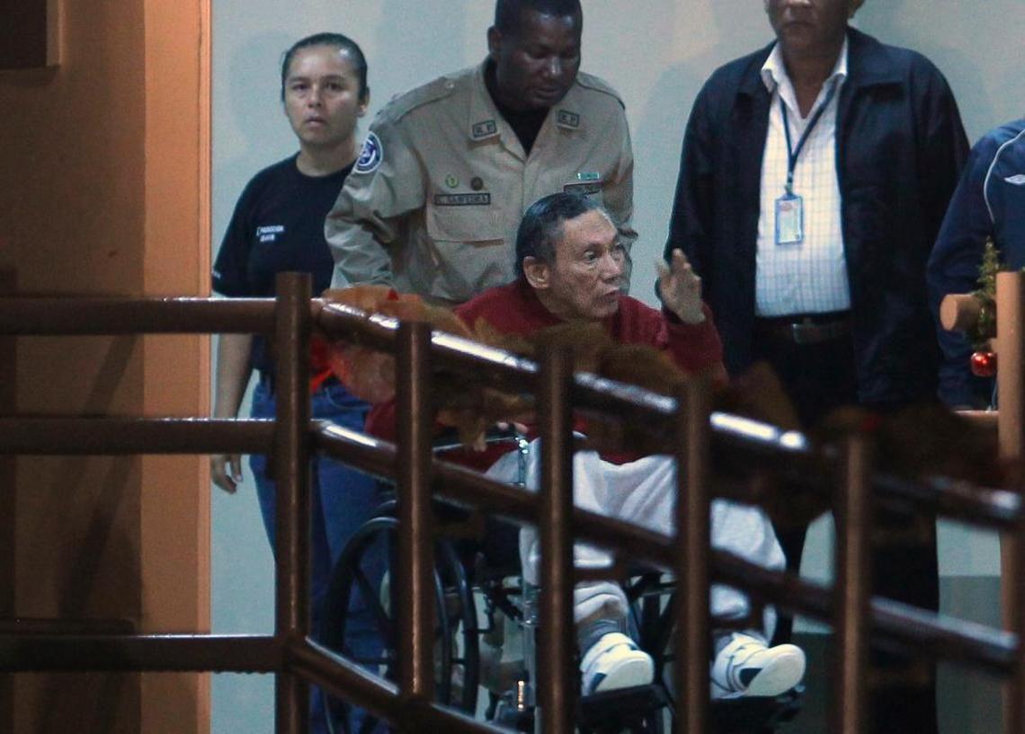 In this Dec. 11, 2011, file photo, Panamanian former dictator Manuel Noriega is pushed in a wheelchair by a police officer inside El Renacer prison on the outskirts of Panama City. Noriega, 83, is in critical condition after undergoing two brain surgeries Tuesday, March 7, 2017.