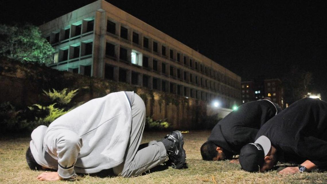Three freed Guantánamo Bay detainees, who were resettled in Uruguay, pray during their protest outside the U.S. embassy in Montevideo, Uruguay, Friday, April 24, 2015.