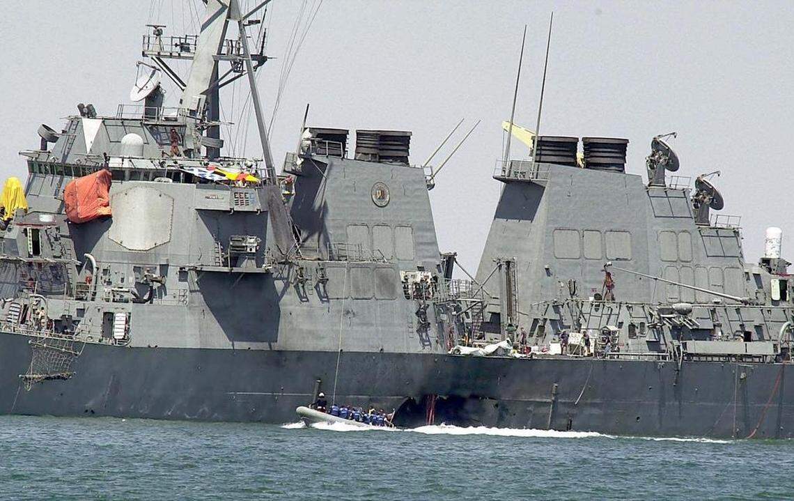 This Oct. 15, 2000 file photo shows investigators in a speed boat examining the hull of the USS Cole at the Yemeni port of Aden, after a powerful explosion ripped a hole in the U.S Navy destroyer.