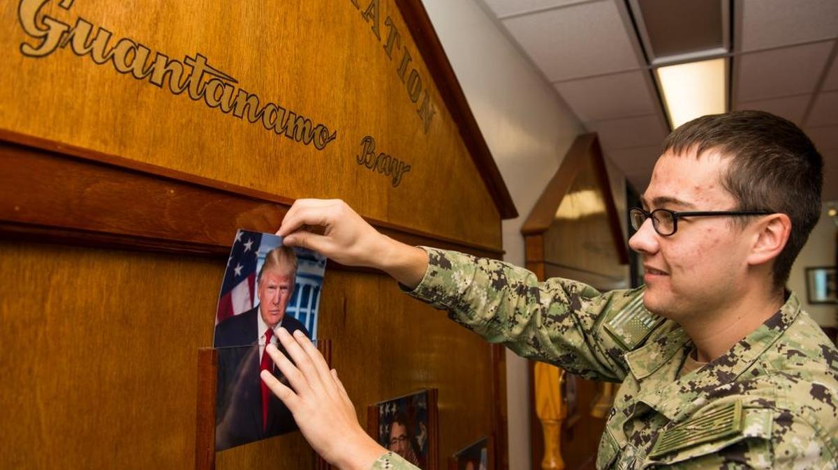 An American sailor inserts President Donald Trump’s photo into a dignitaries’ board at the headquarters of the U.S. Navy base at Guantánamo Bay, Cuba, on Jan. 21, 2017.