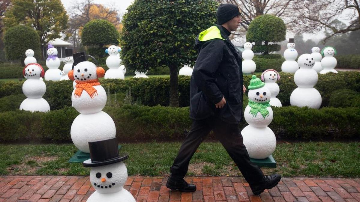 A member of the Secret Service Uniform Division walks though a display outside the East Colonnade of the White House in Washington, Wednesday, Dec. 2, 2015, of 56 ‘snow people’ that represent the number of states and territories in the U.S. during a preview of the 2015 White House holiday decor.