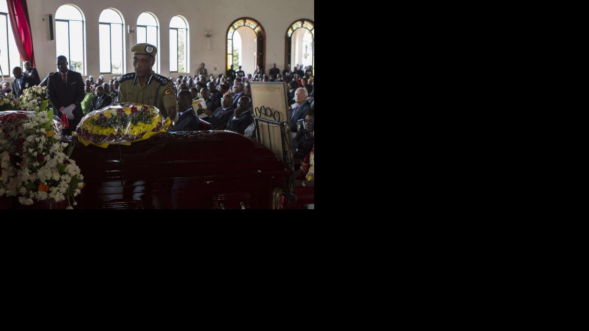 
Uganda’s inspector general of police Kale Kayihura lays a wreath of flowers on a casket carrying the remains of prosecutor Joan Kagezi on April 2, 2015 in Kampala. She was gunned down in a suburb of Kampala, on March 30, 2015. The state attorney, who was handling the on-going trial of 13 men accused of participating in 2010 Al-Shabab bombings that killed 76 people, was reportedly shot by two assailants who had been trailing her on a motorcycle. 
