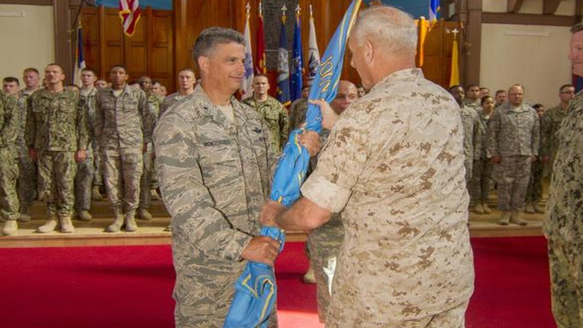At left, Air Force Reserve Brig. Gen. Jose Moneagudo is installed as the 15th commander of Guantánamo detention operations by his boss, Marine Gen. John F. Kelly as the 14th commander, Navy Rear Adm. Kyle Cozad looks on, at right, in a church as the U.S. Navy base in Cuba