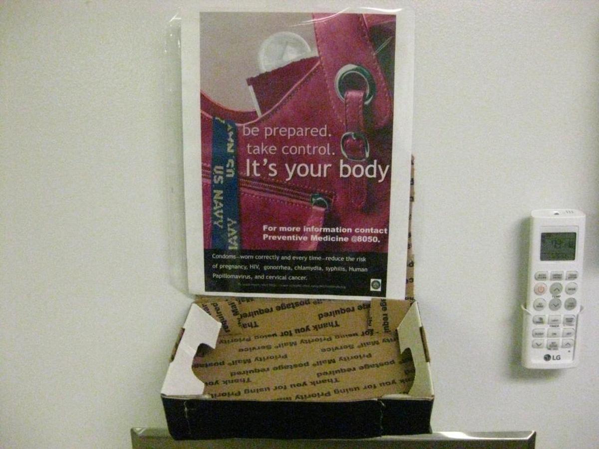An empty box beneath a poster urging safe sex, including condom use, in a bathroom for female troops at Guantánamo’s Camp 6 prison building on Saturday, June 3, 2017 in a photo approved for release by the U.S. military.