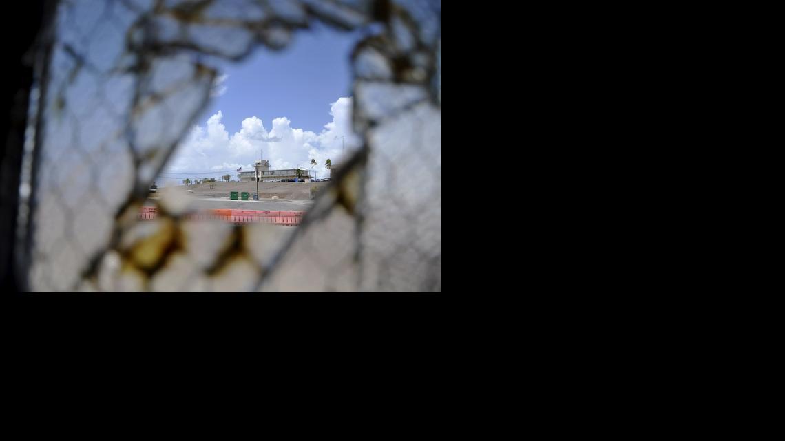 
This Aug. 23, 2013 pool file photo reviewed by the U.S. Department of Defense shows Guantánamo Bay’s now disused medium security courthouse building as seen through a broken window at Camp Justice war court compound at the U.S. Navy base at Guantánamo Bay, Cuba. U.S. military censors forbid photography of the actual courthouse where the war court judges work. It’s a corrugated metal topped prefabricated building that looks like a warehouse.
