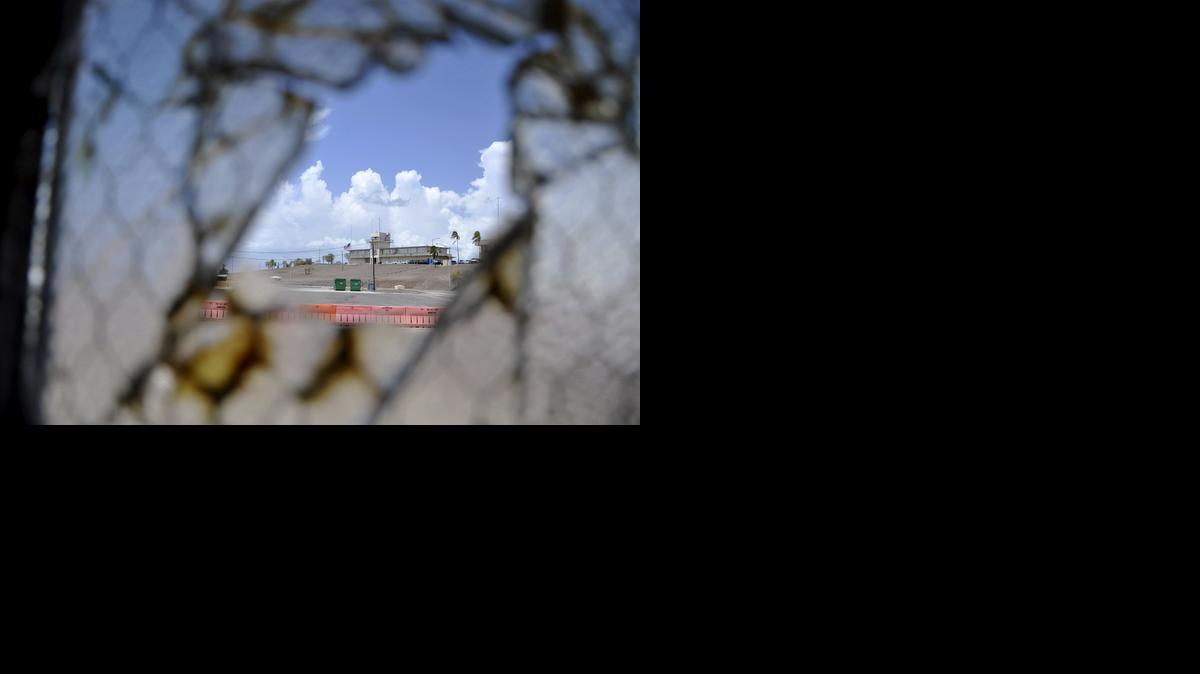 
This Aug. 23, 2013 pool file photo reviewed by the U.S. Department of Defense shows Guantánamo Bay’s now disused medium security courthouse building as seen through a broken window at Camp Justice war court compound at the U.S. Navy base at Guantánamo Bay, Cuba. U.S. military censors forbid photography of the actual courthouse where the war court judges work. It’s a corrugated metal topped prefabricated building that looks like a warehouse.
