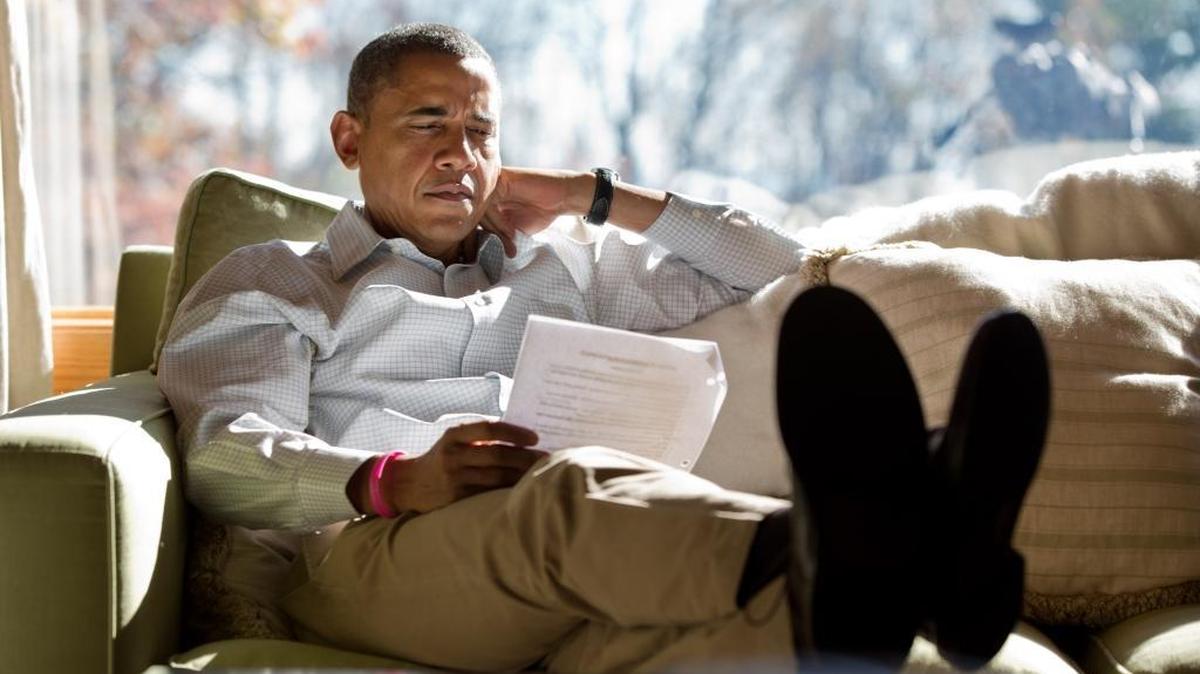 President Barack Obama reads briefing material while meeting with advisors inside his cabin at Camp David on Oct. 21, 2012 in this official White House photo.