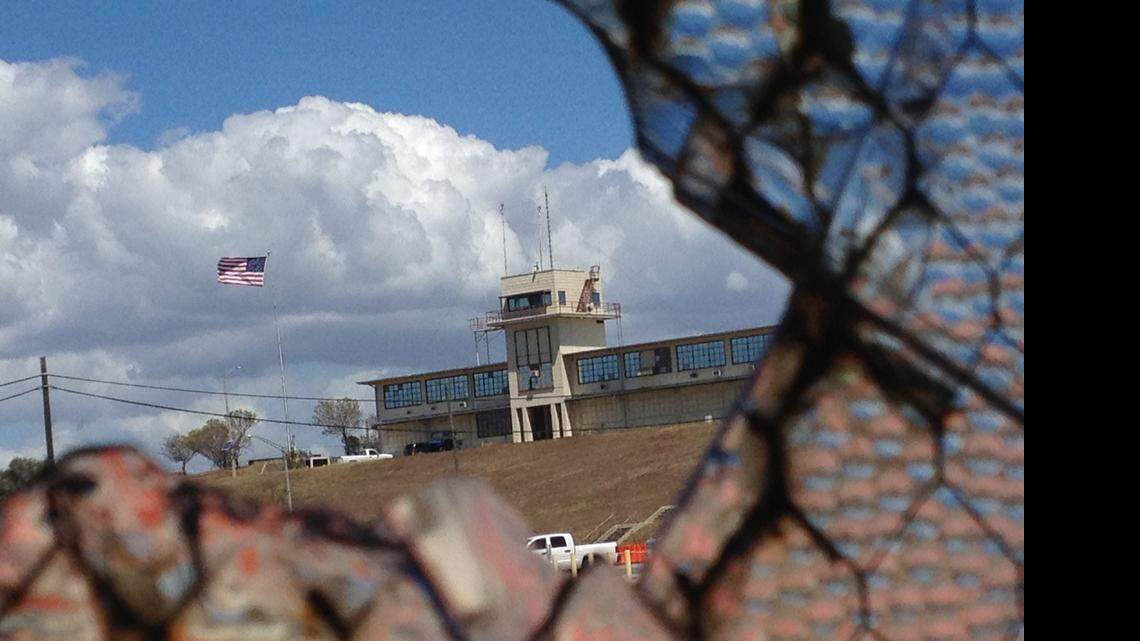 
The flag flying over the war court complex, Camp Justice, as seen through a broken abandoned air hangar window at the U.S. Navy base at Guantánamo Bay, Cuba, on Feb. 28, 2015, in an image approved for release by the U.S. military.
