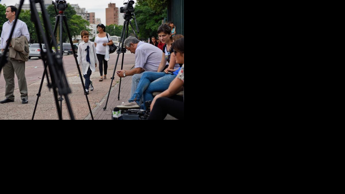 
A boy passes by journalists waiting Monday outside the military hospital where six former Guantánamo Bay prisoners are being kept, in Montevideo.
