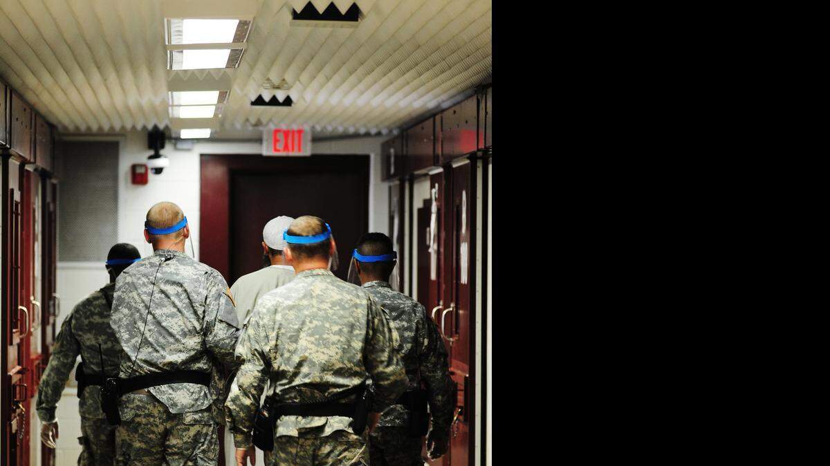 
Guards escort a detainee from his cell in Camp 5, Guantánamo’s maximum-security lockup for low-value detainees in this Oct. 18, 2011 photo released by the prison.
