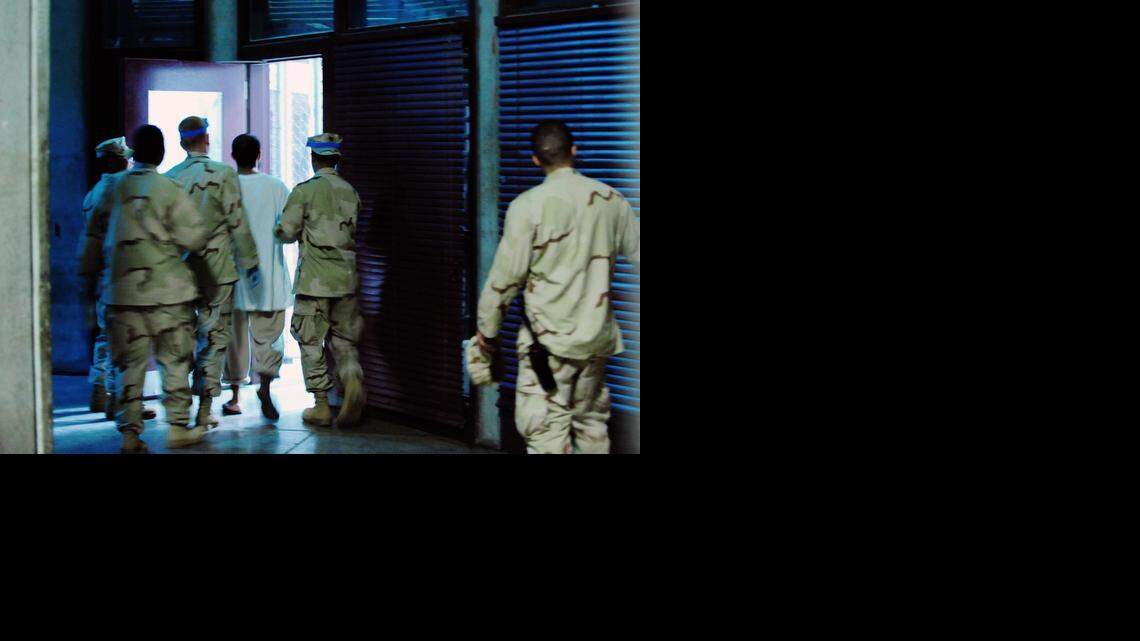 
Guantánamo guards escort a detainee inside Camp 6, a prison building that permits some communal confinement, on Oct. 9, 2011 in this U.S. military handout photo. 


