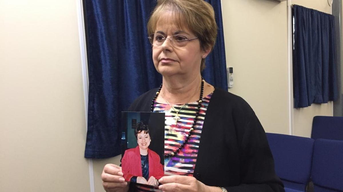 Theresa Corio holds up a photo of her sister Diane Marie Urban, who was killed in the World Trade Center on 9/11, after a news conference Oct. 14, 2016 at the close of a four-day pretrial hearing at the U.S. Navy base at Guantánamo Bay, Cuba.