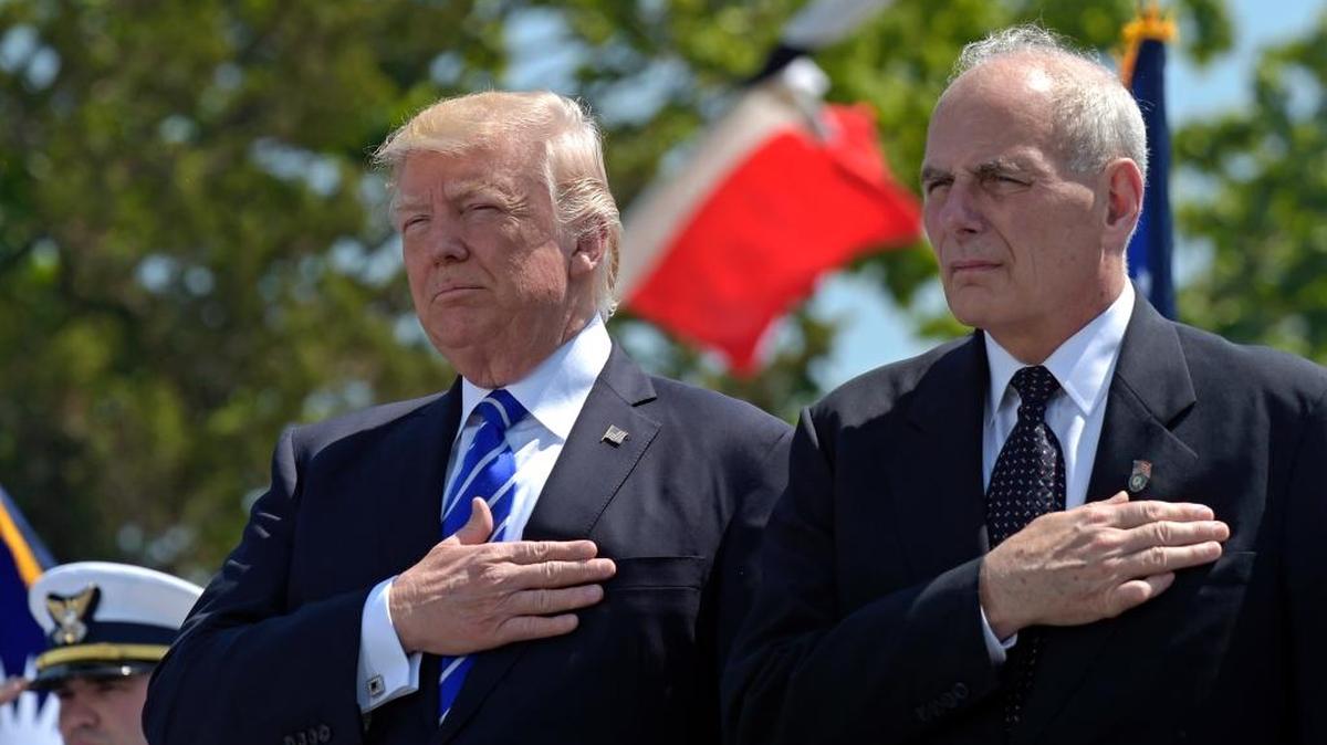 In this May 17, 2017, file photo, President Donald Trump and Homeland Security Secretary John Kelly listen to the national anthem during commencement exercises at the U.S. Coast Guard Academy in New London, Conn.