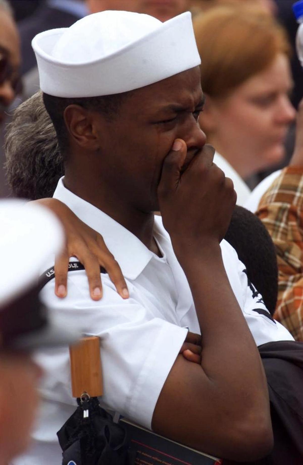 An injured sailor from aboard the USS Cole cries during a memorial service at Norfolk Naval Station on October 18, 2000.