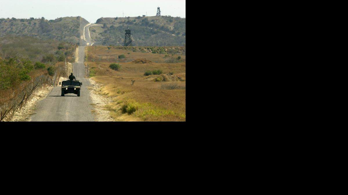 
ISOLATED LAND: A U.S. Marines Humvee patrols the fence line that divides the U.S. Navy base at Guantánamo Bay, Cuba.  
