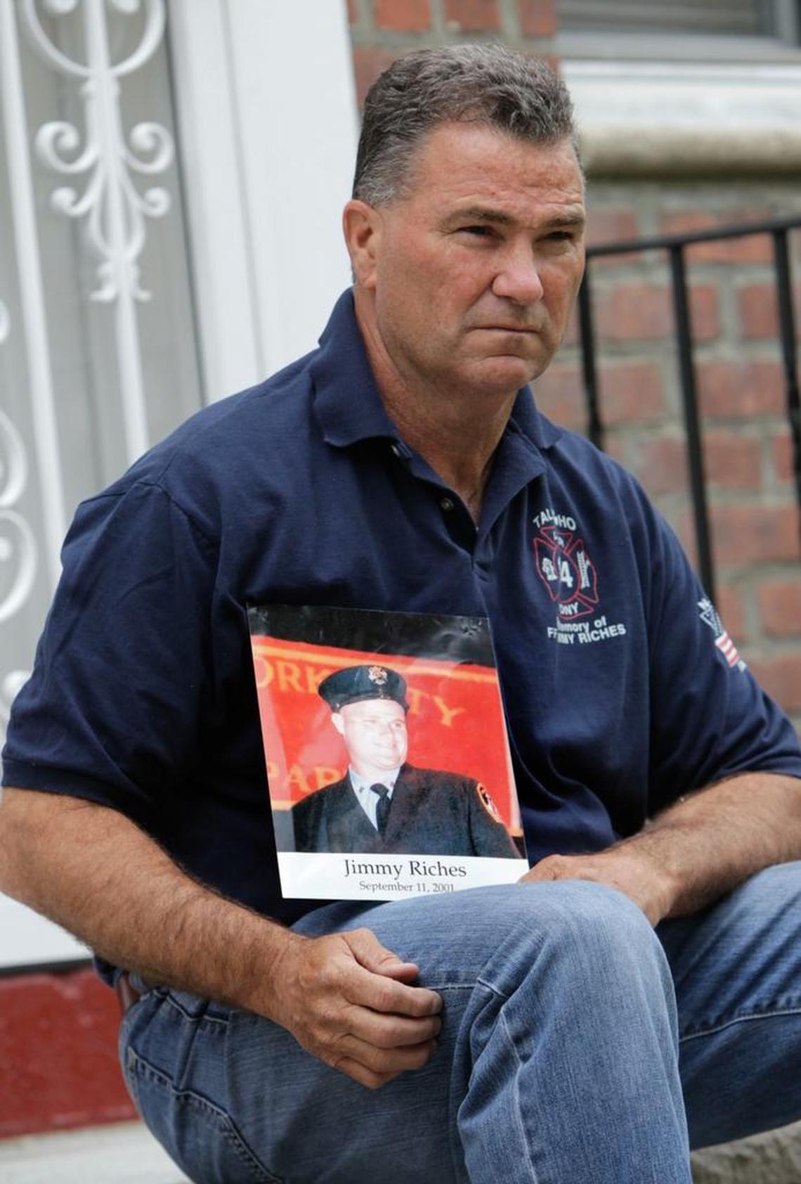Retired firefighter Jim Riches poses for a picture with a photography of his son near his home in New York, May 3, 2012.