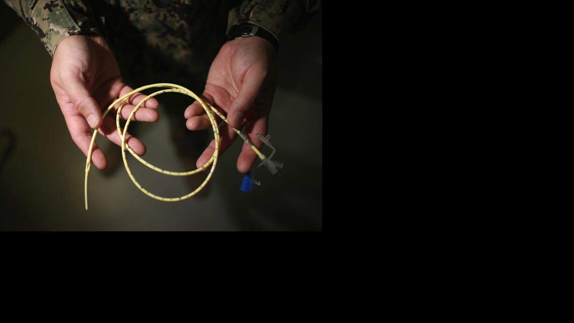 
A Navy doctor holds a feeding tube used to deliver a can of Ensure up the nose, down the back of the throat and into the stomach of a prison camp hunger striker on June 26, 2013 at the U.S. Navy base at Guantánamo Bay, Cuba. The military reviewed this photo as a condition of release.
