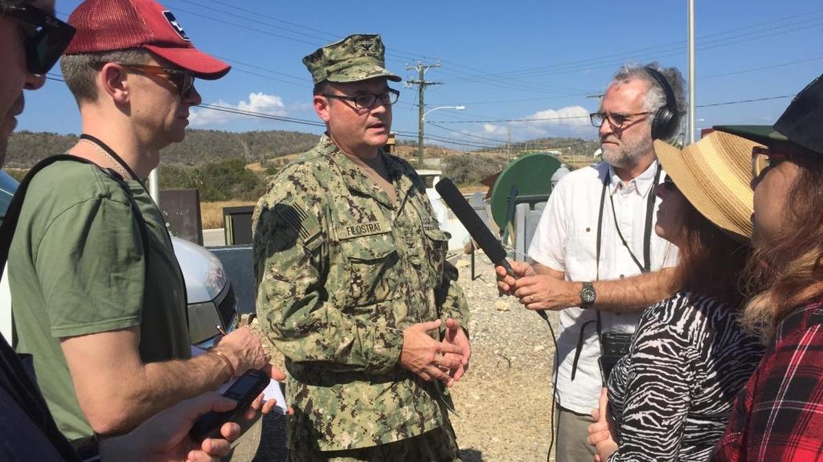 Navy Capt. John Filostrat, center, briefs international reporters on the first media opportunity inside the Detention Center Zone since President Donald Trump took office.