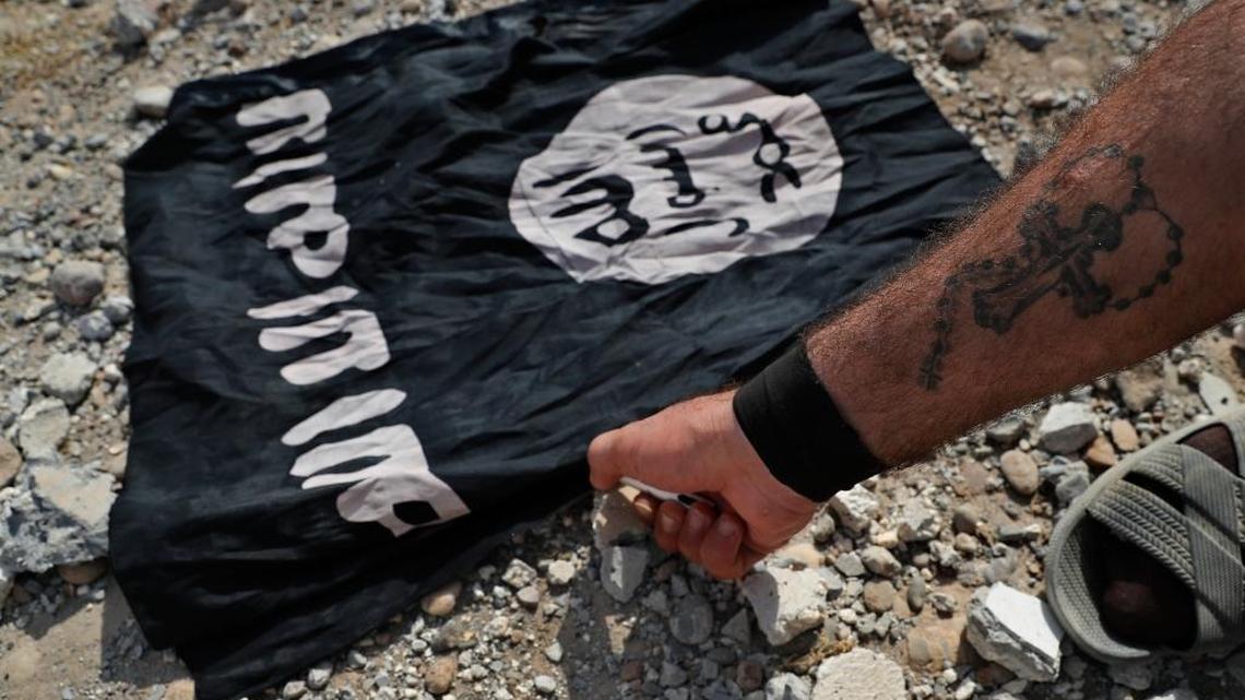 A Syrian Democratic Forces fighter burns an ISIS flag on the front line on the western side of Raqqa, northeast Syria, Monday, July 17, 2017