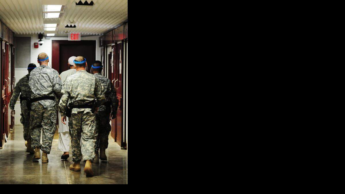 
Guards escort a detainee from his cell in Camp 5, Guantánamo’s maximum-security lockup for low-value detainees in this Oct. 18, 2011 photo released by the prison.
