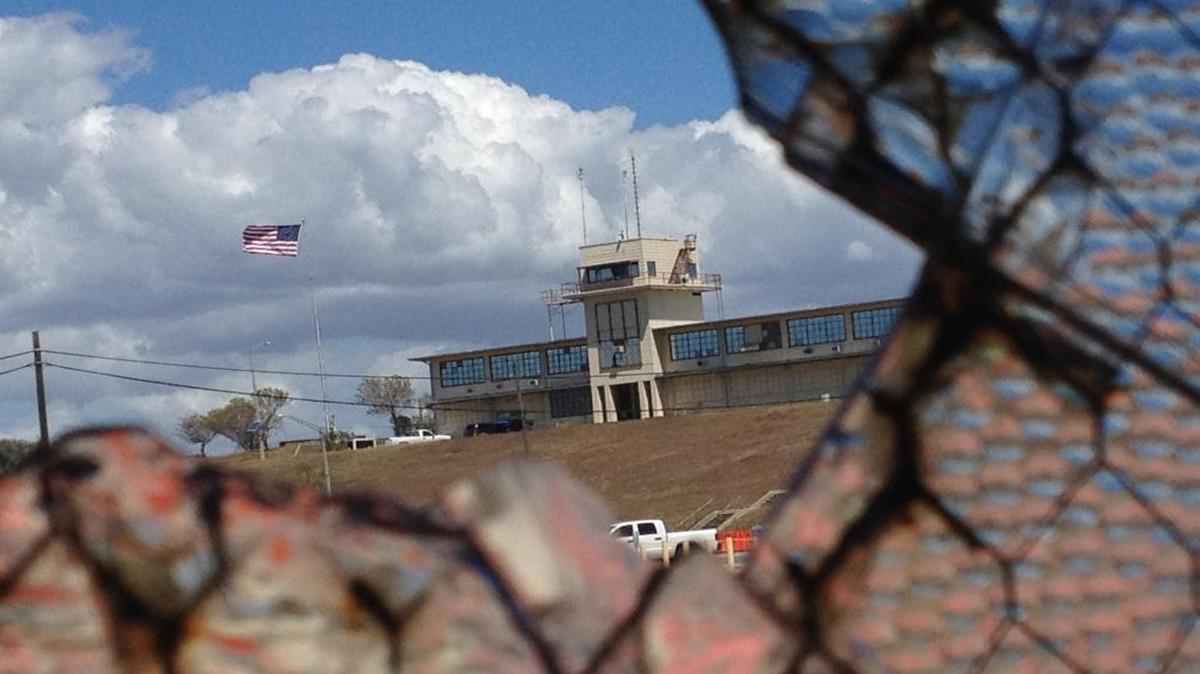 The headquarters building of the war court complex called Camp Justice as seen through a broken window at an obsolete air hangar at the U.S. Navy base at Guantánamo Bay, Cuba, on Feb. 28, 2015, in an image approved for release by the U.S. military.