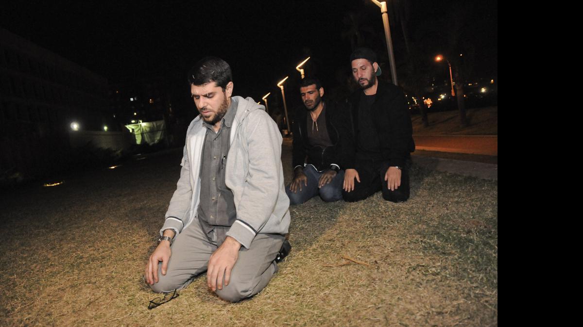 
Three freed Guantánamo Bay detainees, who were resettled in Uruguay, pray during their protest outside the U.S. Embassy in Montevideo, Uruguay, Friday, April 24, 2015. From left are Omar Abdelahdi Faraj and Ali Husain Shaaban, both of Syria, and Adel bin Muhammad El Ouerghi of Tunisia. The men are protesting after they were asked to leave a hotel where some stayed periodically, and demand Washington help them financially. They say the house where they were initially resettled didn't have enough space for all of them. The men spent 12 years at the U.S. military prison but were never charged and released after officials determined they were no longer a threat. 
