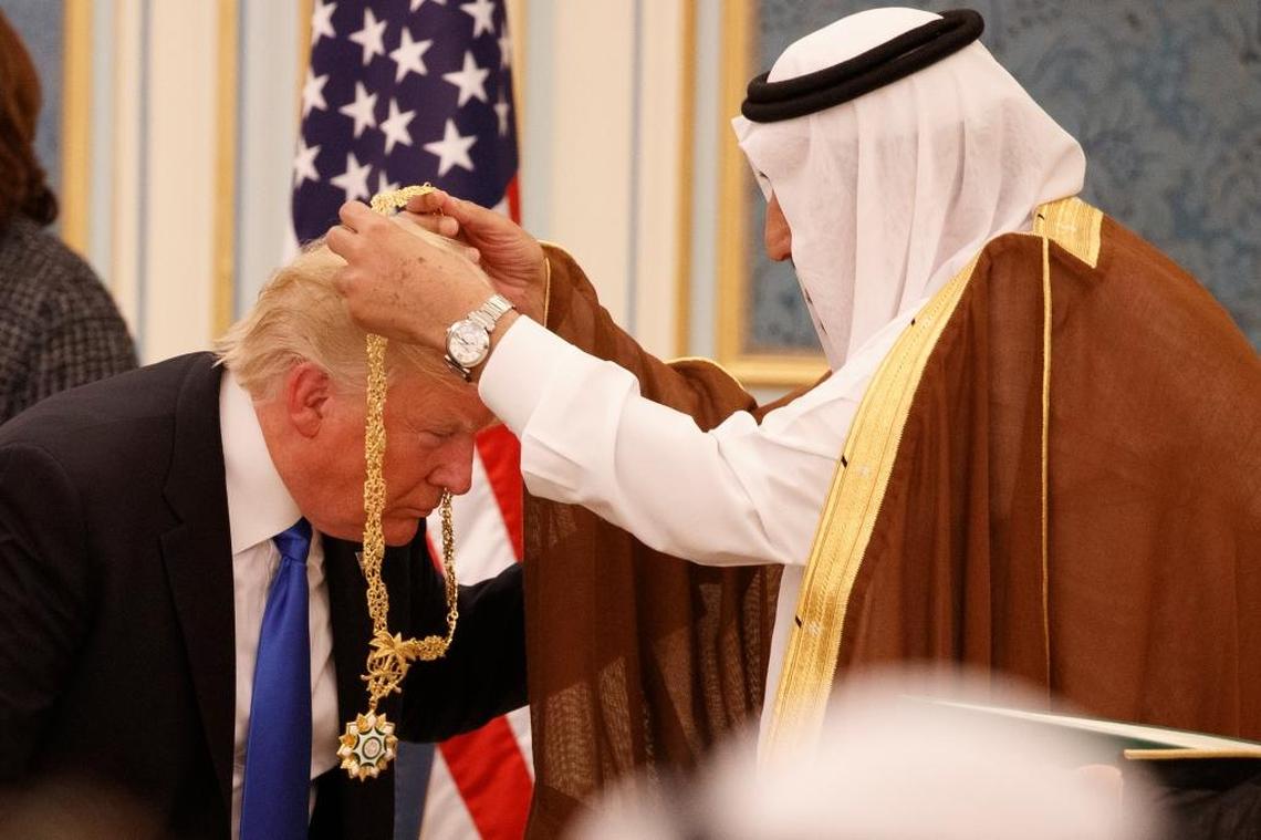 In this Saturday, May 20, 2017 file photo, Saudi King Salman presents President Donald Trump with the highest civilian honor, the Collar of Abdulaziz Al Saud, at the Royal Court Palace, in Riyadh, Saudi Arabia. Trump had to bend down so the king could put the gold medal hanging from a long, gold chain around his neck, and that ignited debate over whether he had bowed to the king.