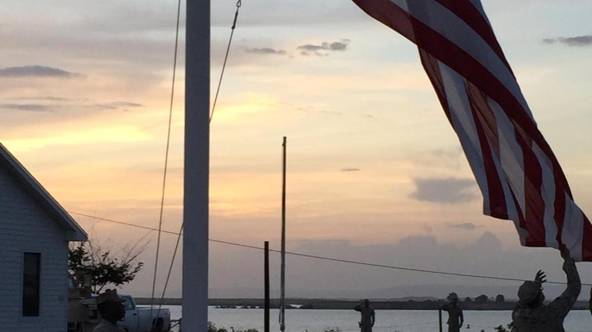 
Members of the Marine Corps stationed at the U.S. Navy base at Guantánamo Bay, Cuba, lower the Stars and Stripes for the night on Monday, July 20, 2015, a time-honored ritual called “lowering the colors” — on the day the United States and Cuba restored full diplomatic relations. 
