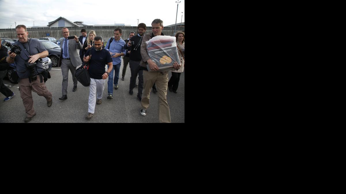 
British Moazzam Begg, center, leaves Belmarsh Prison in south London, after his release, Wednesday, Oct. 1, 2014. British prosecutors dropped terrorism charges Wednesday against the former Guantánamo Bay detainee who is a high-profile advocate for the rights of terror suspects. Begg, who had been in prison for seven months awaiting trial, was due to stand trial next week on seven counts relating to the war in Syria. But in a last-minute reversal, prosecutors acknowledged that new evidence had emerged that undermined the case. 
