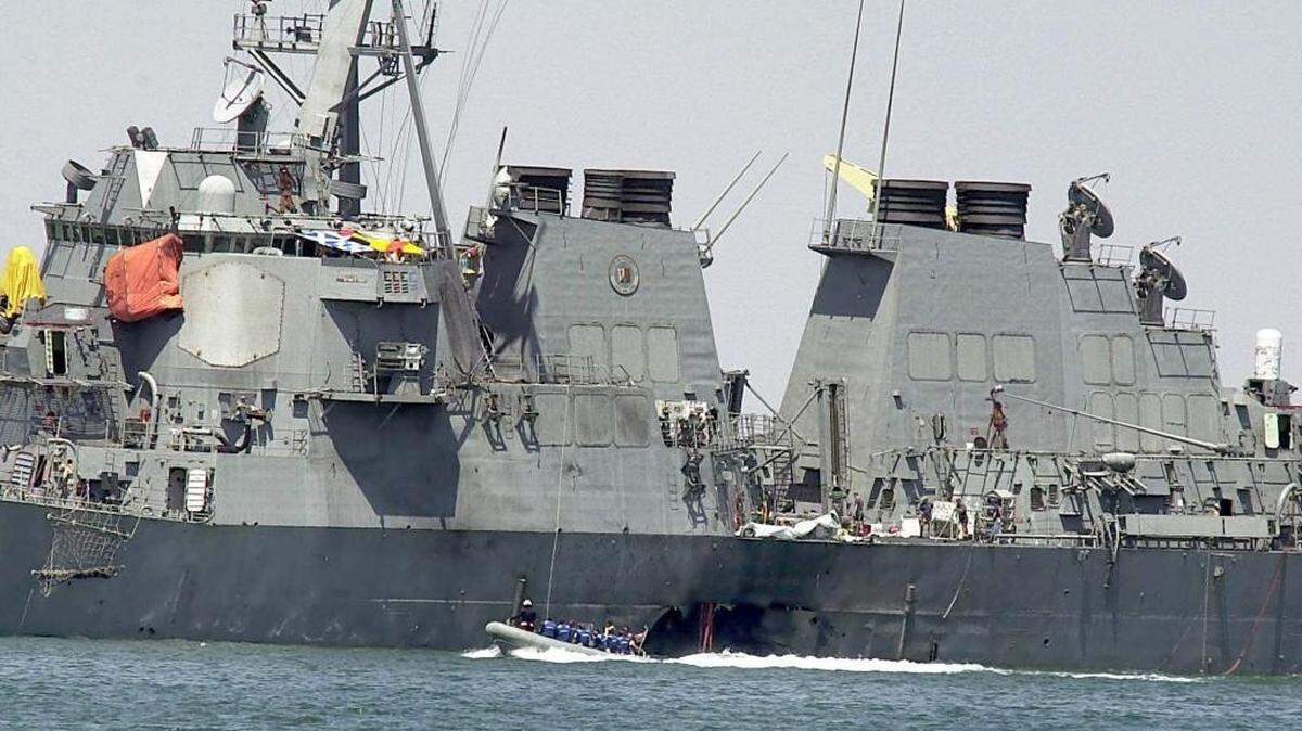 This Oct. 15, 2000, file photo shows investigators in a boat examining the hull of the USS Cole at the Yemeni port of Aden, after a powerful explosion ripped a hole in the U.S Navy destroyer.