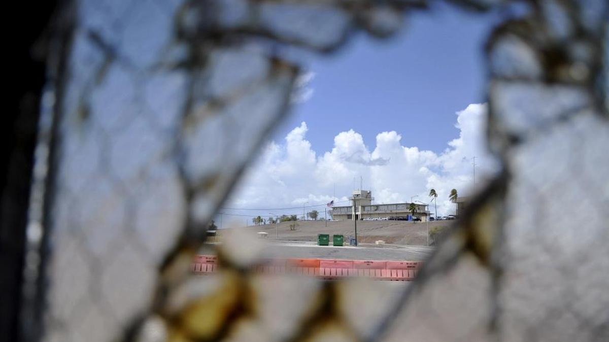 
If approved, an Expeditionary Legal Complex expansion would add more Top Secret offices for defense lawyers assigned to former CIA captives cases in the parking lot of Camp Justice, seen through a broken window below the hilltop building that houses a little used courtroom. It is shown in this Aug. 23, 2013 pool photo approved for release by the U.S. military.
