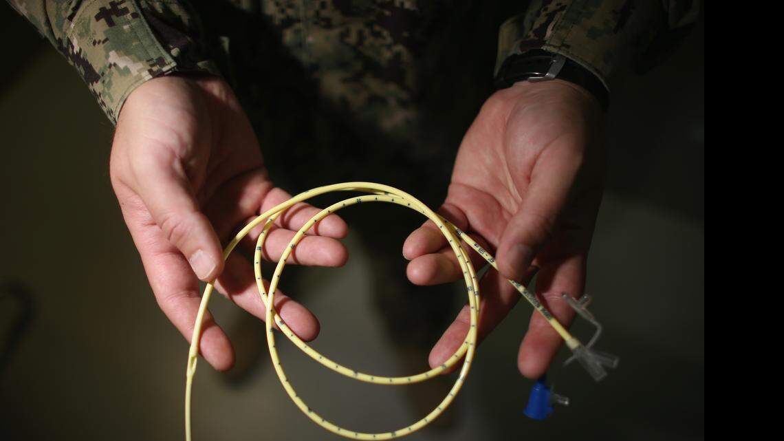 
A Navy doctor holds a feeding tube used to deliver a can of Ensure up the nose, down the back of the throat and into the stomach of a prison camp hunger striker on June 26, 2013 at the U.S. Navy base at Guantánamo Bay, Cuba. The military reviewed this photo as a condition of release.
