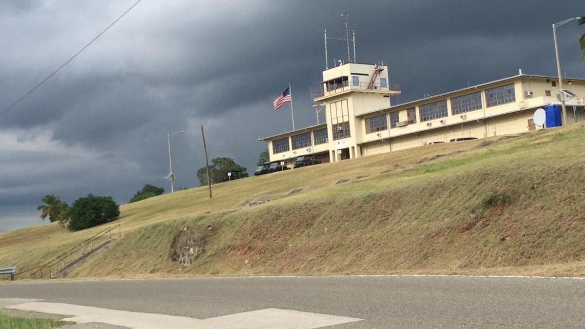 Storm clouds over war court headquarters on Oct. 30, 2017, at the U.S. Navy base at Guantánamo Bay, Cuba, in a photo approved for release by the U.S. military. An Army prosecutor announced at the war court Friday that a space in the building housing a defunct courtroom, the judge’s chambers and administrative offices could be used for a prisoner to consult with his lawyers.