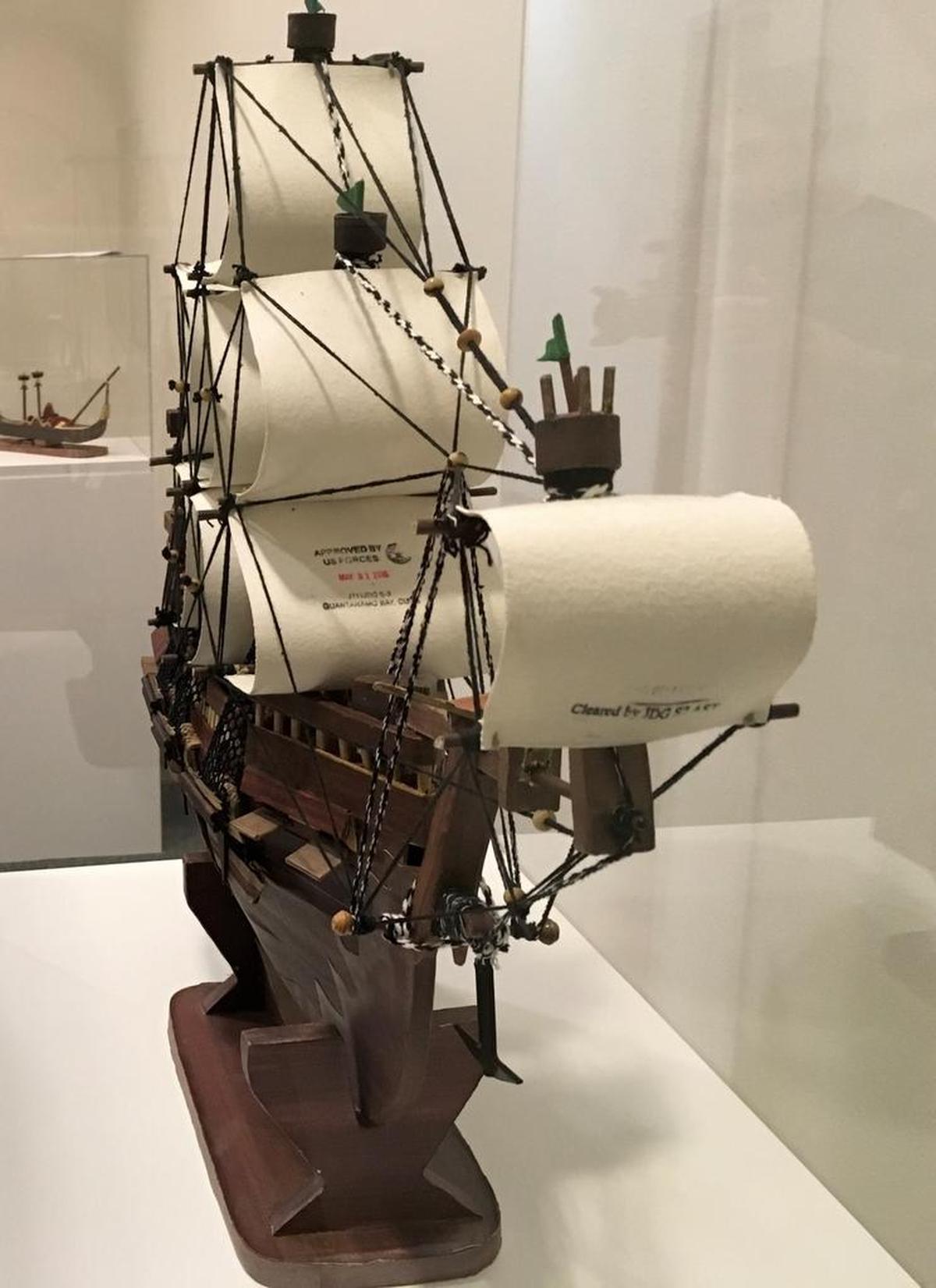 The prison at Guantánamo Bay, Cuba, put its stamp of approval for release on the sail of this model ship built by Yemeni captive Moath al Alwi from paper and other found objects at the Camp 6 communal prison for low value detainees. It was on display on Oct. 25, 2017 at the John Jay College of Criminal Justice as part of an exhibit of art made at the prison by captives past and present.