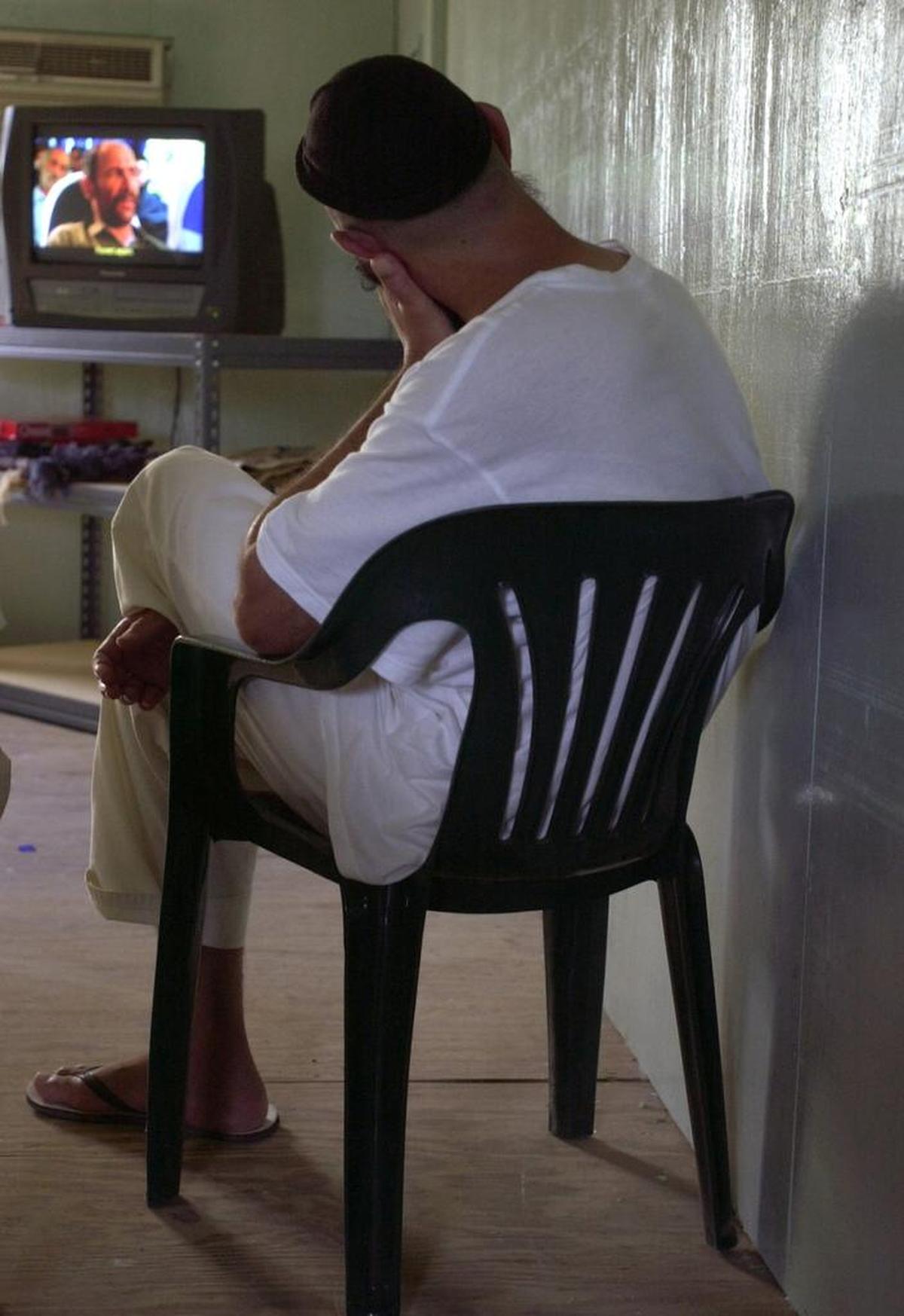 In this photo reviewed by U.S. military officials, a detainee watches the Iranian movie ‘The Color of Paradise’ inside a trailer in Camp Iguana at the Guantánamo Bay Navy base, Cuba on Thursday, July 1, 2004.