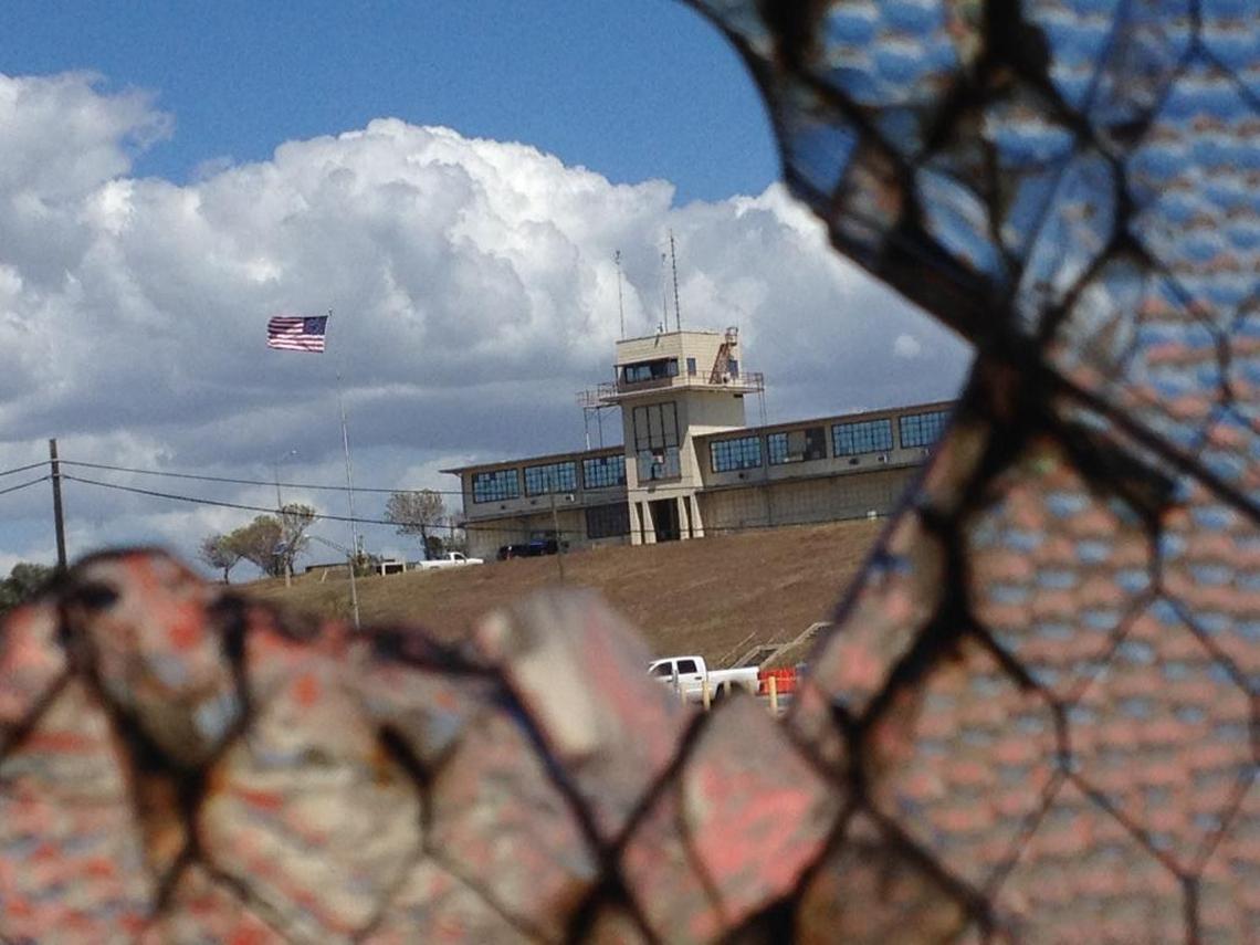 The war court complex called Camp Justice as seen through a broken window at an obsolete air hangar at the U.S. Navy base at Guantánamo Bay, Cuba, on Feb. 28, 2015, in an image approved for release by the U.S. military.