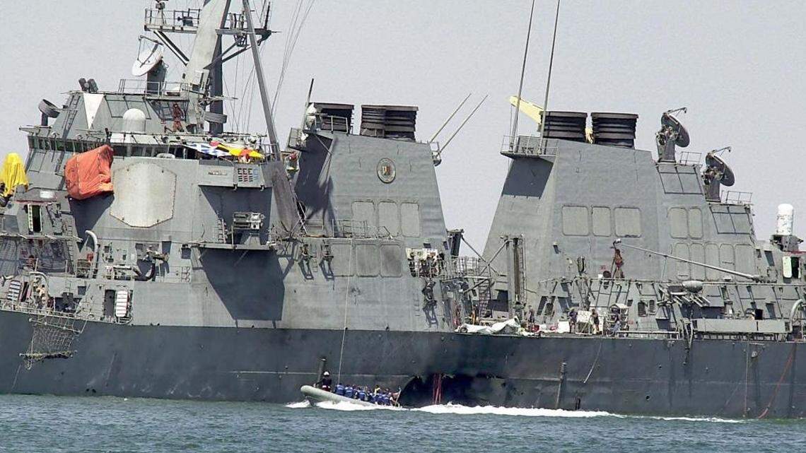 This Oct. 15, 2000 file photo shows investigators in a speed boat examining the hull of the USS Cole at the Yemeni port of Aden, after a powerful explosion ripped a hole in the U.S Navy destroyer.