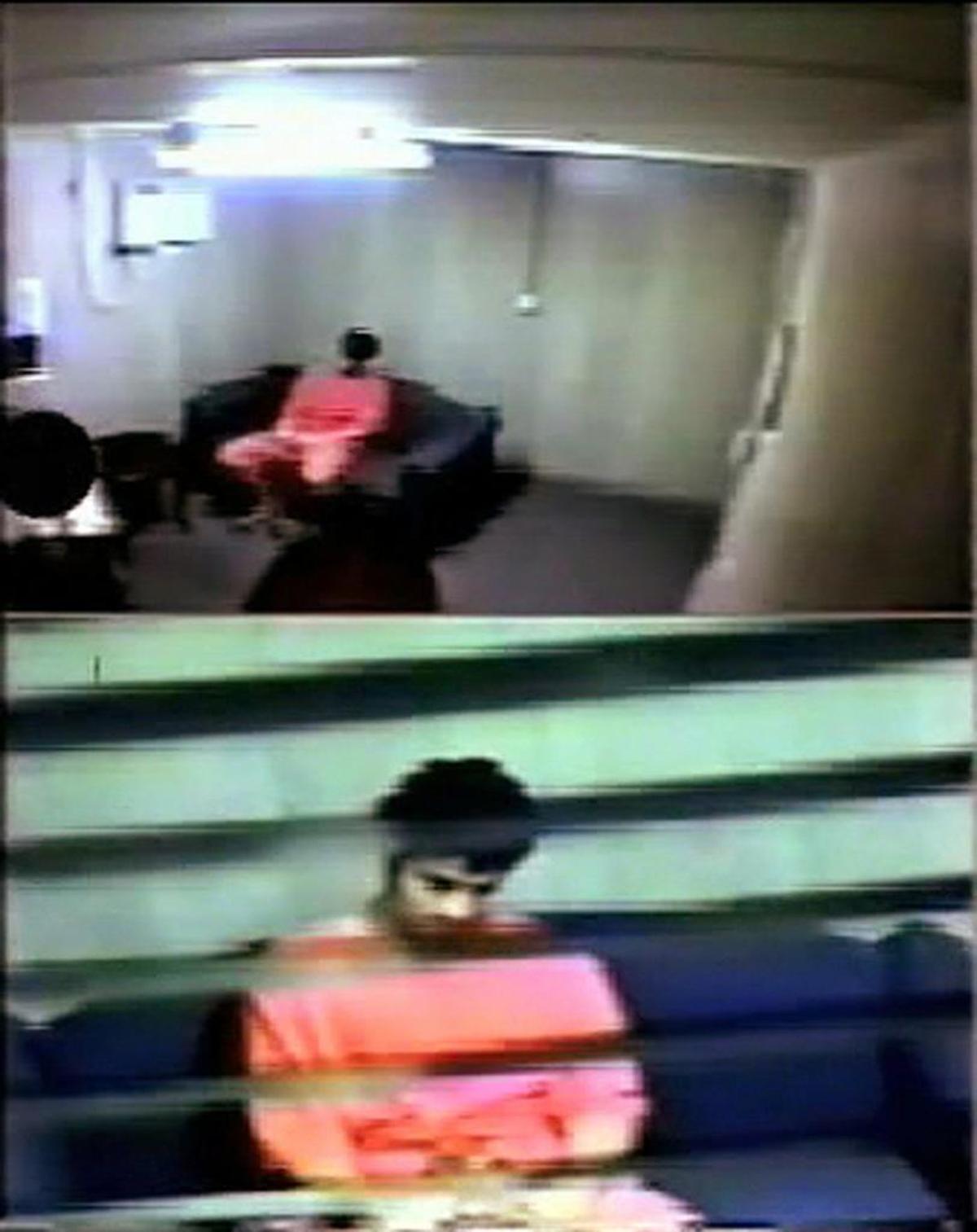 In this handout image taken from a 2003 U.S. Department of Defense surveillance video and released Tuesday July 15, 2008 by Omar Khadr's defense lawyers, Omar Khadr is shown in an interrogation room at the U.S. Navy base at Guantánamo prison while being questioned by members of the Canadian Security Intelligence Service.
