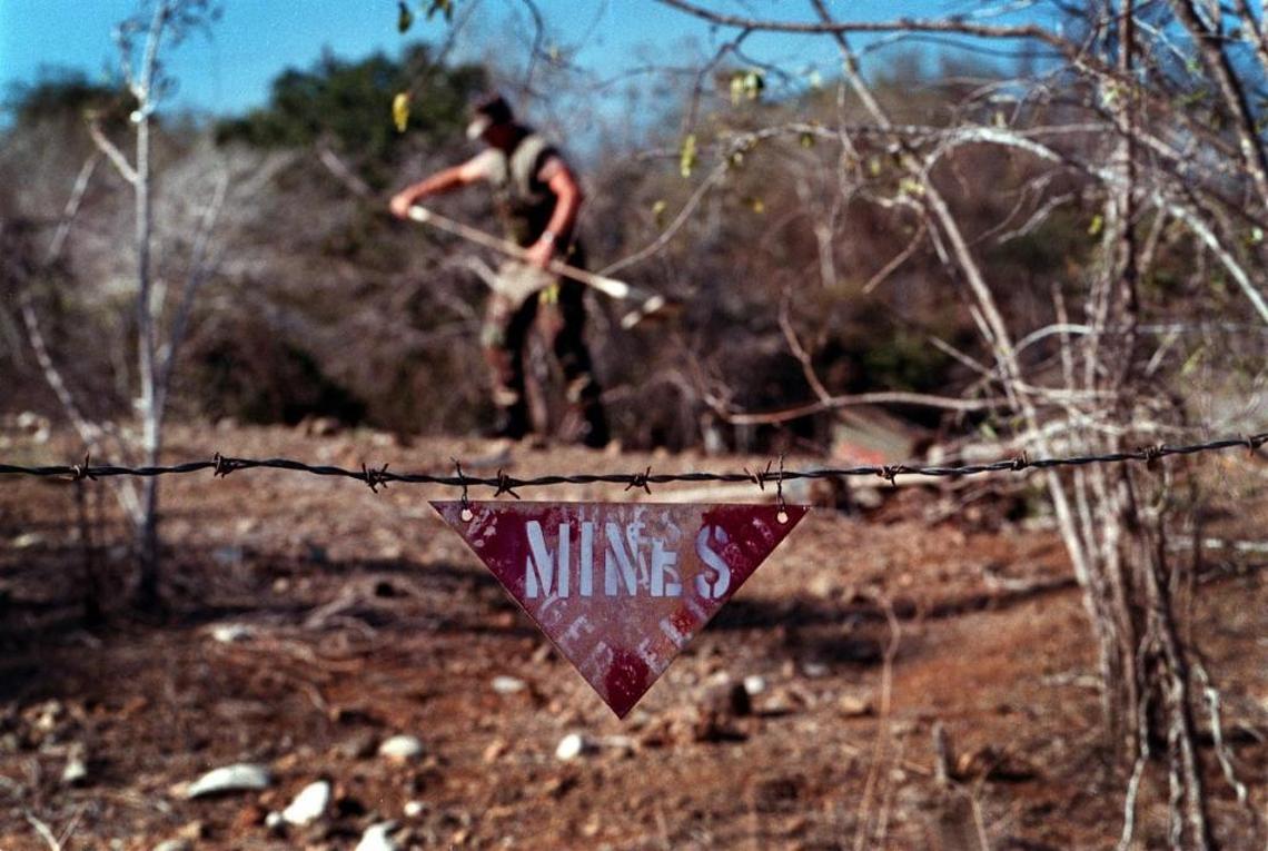 The U.S. Navy base side of Guantánamo Bay, Cuba, on March 19, 1999, during a landmine removal operation. The Cuban minefield remains across the fence line, and there were reports that mines may have exploded as a wildfire spread toward the base this week.