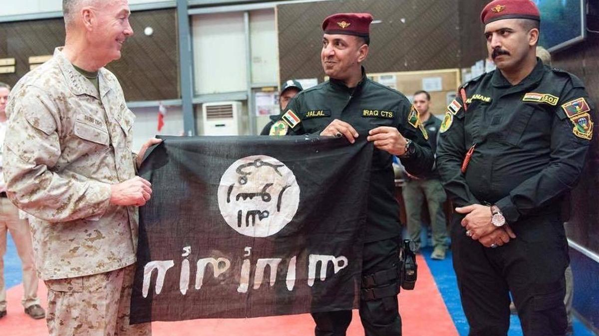 In this Pentagon handout photo, members of the Iraqi Counter Terrorism Service present Marine Gen. Joseph F. Dunford, chairman of the Joint Chiefs of Staff, a flag from Bartilah, a town recaptured by the Iraqi army just outside of Mosul from the Islamic State of Iraq and the Levant, known as ISIS.