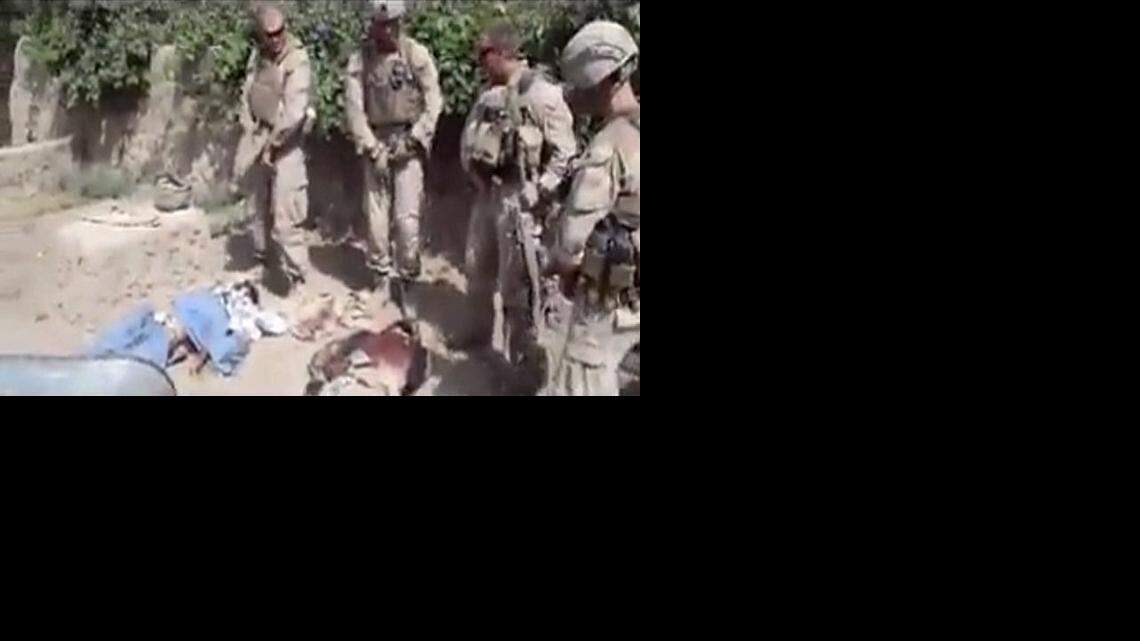 
This image made on Thursday, Jan. 12, 2012 from undated video posted on the Internet on Wednesday, Jan. 11, 2012 by a YouTube user who identified themself as “semperfiLoneVoice” shows men in U.S. Marine combat gear, standing in a semi-circle over three bodies. 
