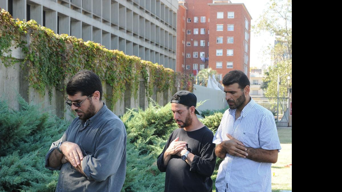 
Former Guantánamo detainees Abdul Bin Muhammad Bin Abbas Ouerghi, center, Ali Husein Shaaban, right, and Abd al-Hadi Omar Mahmoud Faraj, left, pray in front of the U.S. Embassy in Montevideo, on April 27, 2015. 
