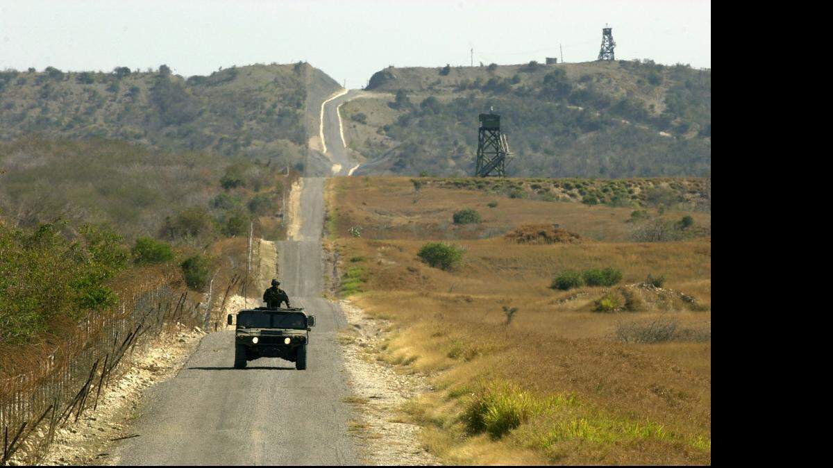 
A U.S. Marines Humvee patrols the fence line that divides the U.S. Navy base at Guantánamo Bay, Cuba, on March 14, 2002.
